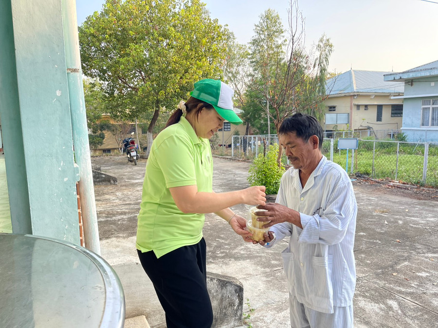 Chị Tâm (bìa trái) niềm nở trao từng suất ăn sáng cho bệnh nhân. Ảnh: Vũ Chi