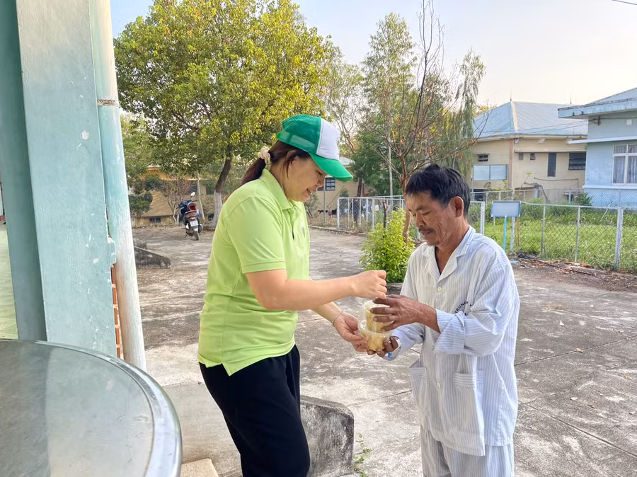 Chị Tâm (bìa trái) niềm nở trao từng suất ăn sáng cho bệnh nhân. Ảnh: Vũ Chi