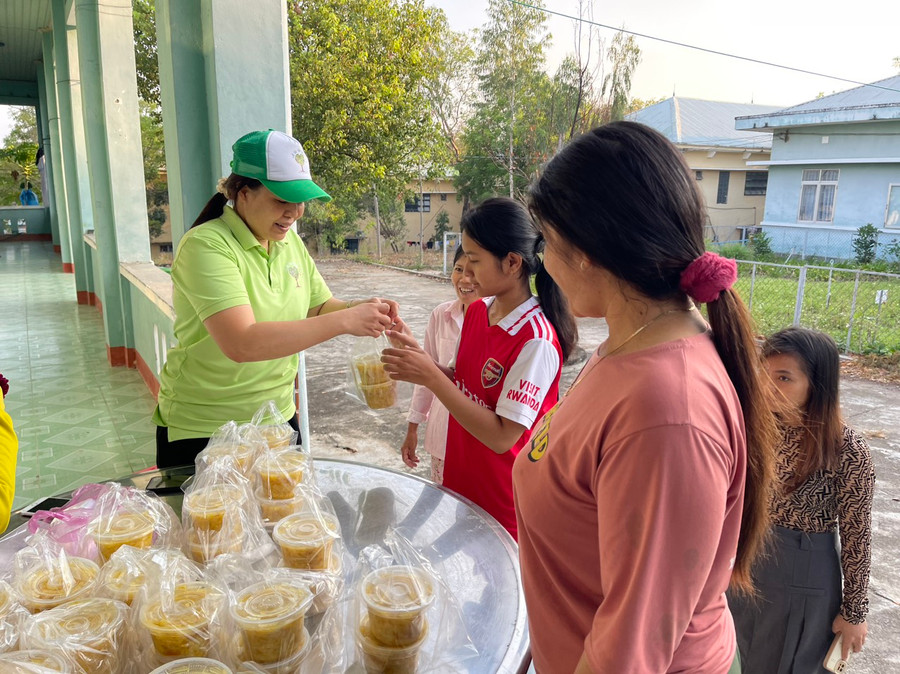 Chị Nguyễn Thị Tâm (bìa trái) cẩn thận đóng hũ từng suất ăn sáng trước khi phát cho bệnh nhân. Ảnh: Vũ Chi