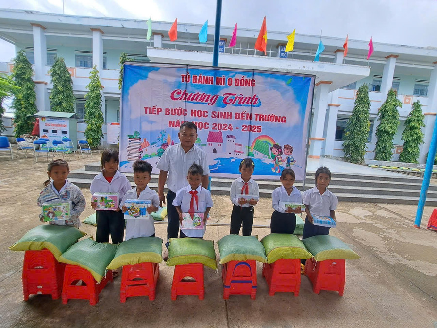 Thầy Đinh Tùng-người đại diện Tủ bánh mì 0 đồng trích kinh phí tủ bánh trao tặng quà cho học sinh nghèo của trường nhân dịp năm học mới. Ảnh: Vũ Chi