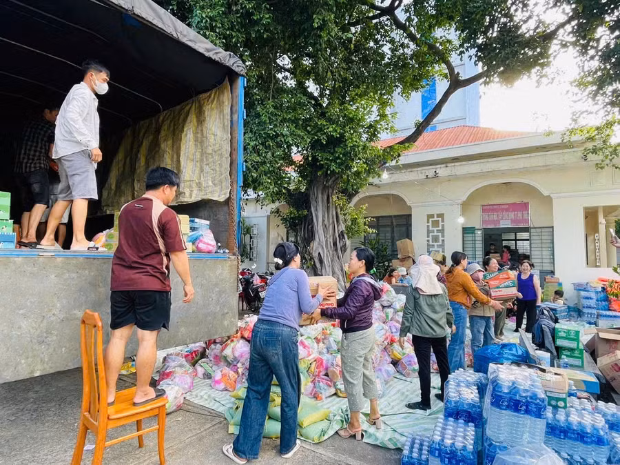 Người dân huyện Phú Thiện tham gia vận chuyển hàng cứu trợ lên xe. Ảnh: Vũ Chi