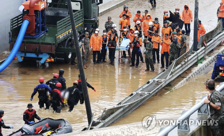 Nhân viên cứu hộ đưa thi thể trong đường hầm ngập nước ra ngoài. Ảnh: Yonhap Nhân viên cứu hộ đưa thi thể trong đường hầm ngập nước ra ngoài. Ảnh: Yonhap