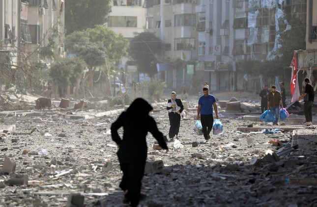 Người dân Palestine phải rời khỏi nhà cửa sau khi Israel ném bom ngày 30-10. Ảnh: AP Người dân Palestine phải rời khỏi nhà cửa sau khi Israel ném bom ngày 30-10. Ảnh: AP