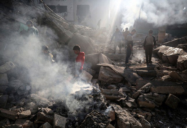 Người Palestine trước đống đổ nát của một nhà thờ Hồi giáo ở Dải Gaza. Ảnh: AP