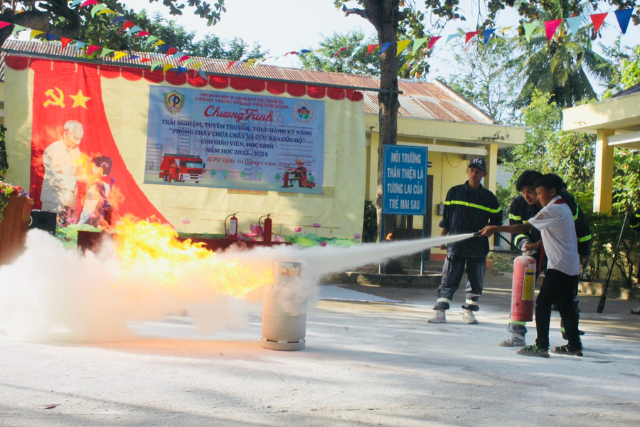 Các em học sinh trải nghiệm chữa cháy do khí gas. Ảnh Vũ Chi