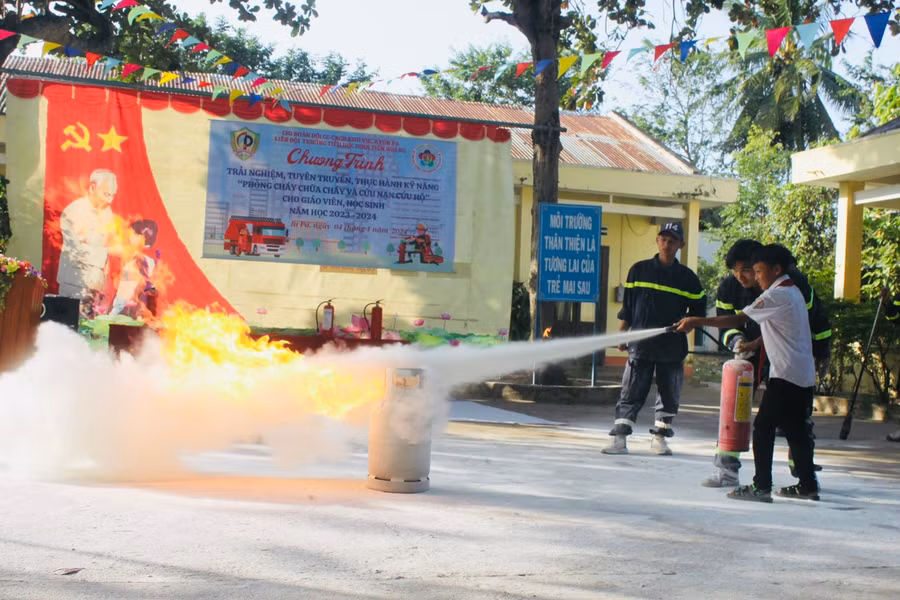 Các em học sinh trải nghiệm chữa cháy do khí gas. Ảnh Vũ Chi