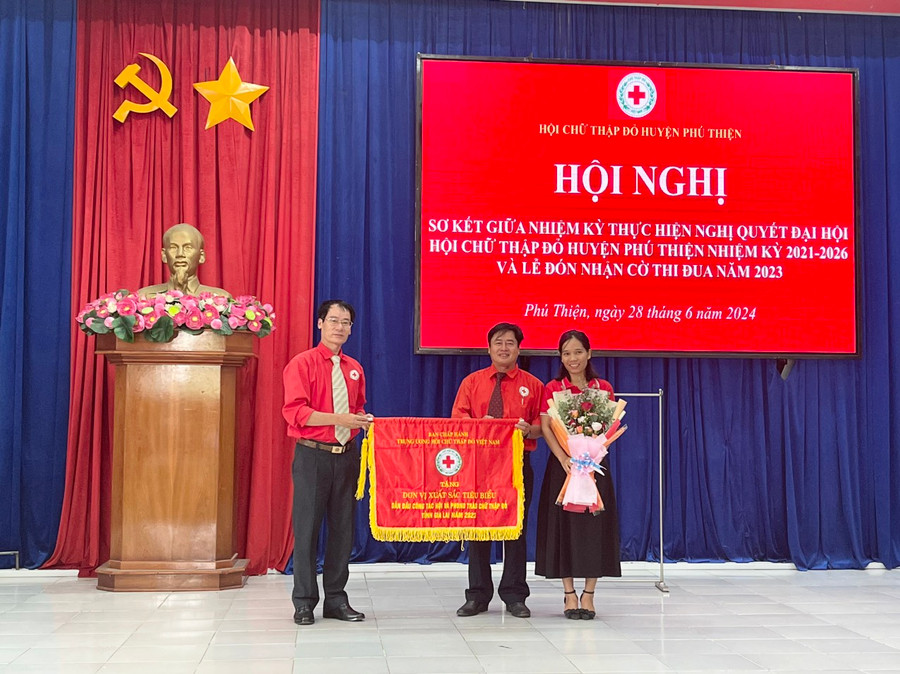 Được sự ủy quyền của Trung ương Hội Chữ thập đỏ Việt Nam, Chủ tịch Hội Chữ thập đỏ tỉnh Dương Đình Diện trao Cờ thi đua cho Hội Chữ thập đỏ huyện Phú Thiện. Ảnh: Vũ Chi