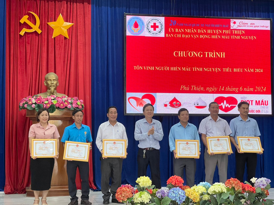 Phó Chủ tịch Thường trực UBND huyện Nguyễn Ngọc Ngô (đứng giữa) tặng giấy khen 6 tập thể có thành tích xuất sắc trong công tác hiến máu tình nguyện. Ảnh: Vũ Chi