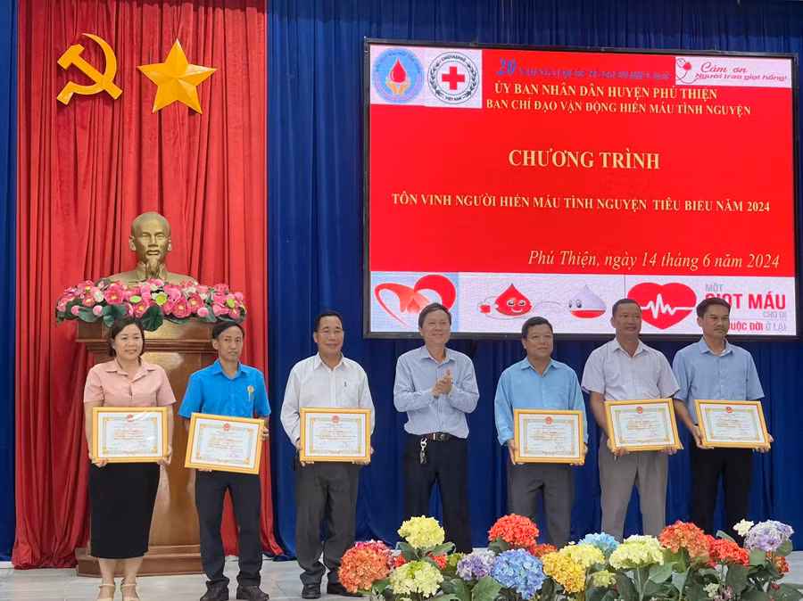 Phó Chủ tịch Thường trực UBND huyện Nguyễn Ngọc Ngô (đứng giữa) tặng giấy khen 6 tập thể có thành tích xuất sắc trong công tác hiến máu tình nguyện. Ảnh: Vũ Chi