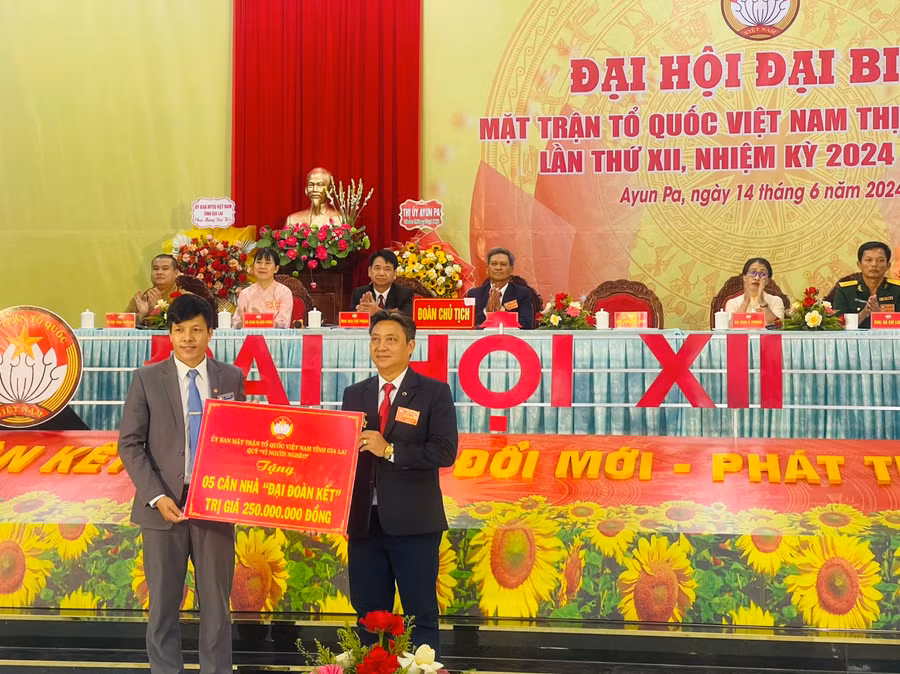 Phó Chủ tịch Ủy ban Mặt trận Tổ quốc Việt Nam tỉnh Đinh Ngọc Hải (bìa trái) tặng bảng tượng trưng 5 căn nhà Đại đoàn kết cho hộ nghèo thị xã. Ảnh: Vũ Chi