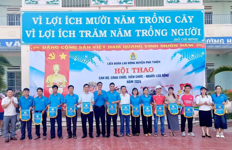 Ban tổ chức trao cờ lưu niệm cho các đoàn tham gia hội thao. Ảnh: Lê Tám