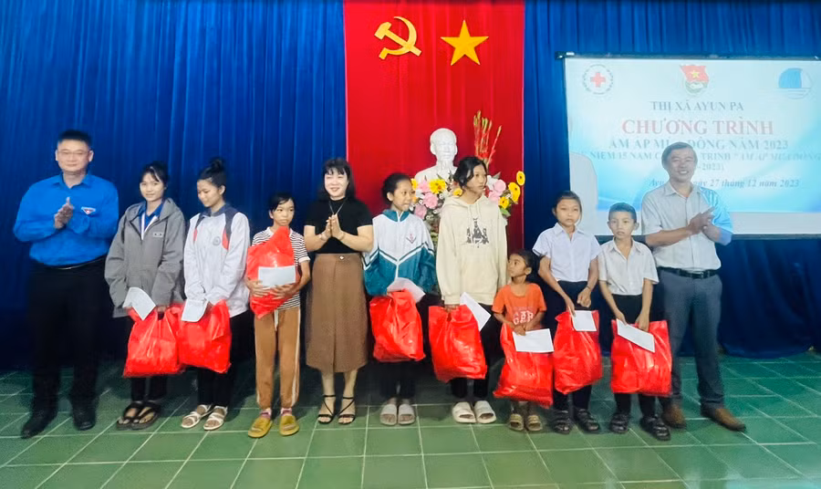 Lãnh đạo Thị Đoàn, Hội Chữ thập đỏ, Phòng Lao động-Thương binh và Xã hội thị xã trao quà cho các em học sinh có hoàn cảnh khó khăn. Ảnh: Vũ Chi