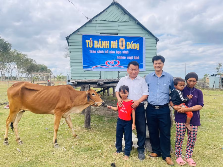 Đại diện Tủ bánh mì 0 đồng trao bò sinh sản cho em Đinh Thảo (học sinh lớp 2.1, Trường Tiểu học và THCS Đinh Núp). Ảnh: Vũ Chi