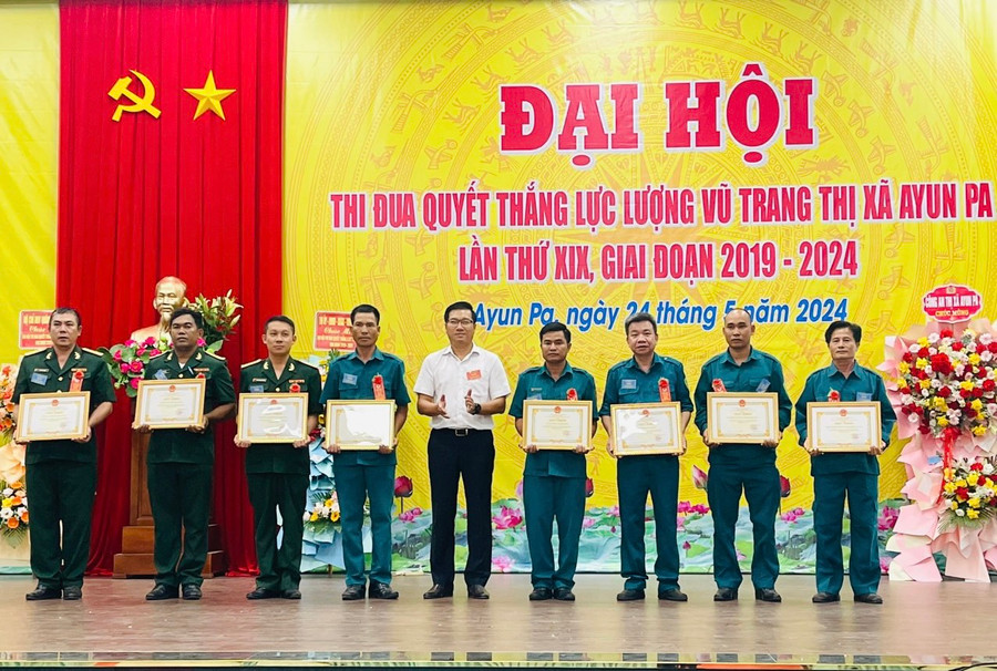Chủ tịch UBND thị xã Ayun Pa Nguyễn Trường Sơn (đứng giữa) tặng giấy khen các tập thể có thành tích xuất sắc trong phong trào thi đua quyết thắng giai đoạn 2019-2024. Ảnh: Vũ Chi
