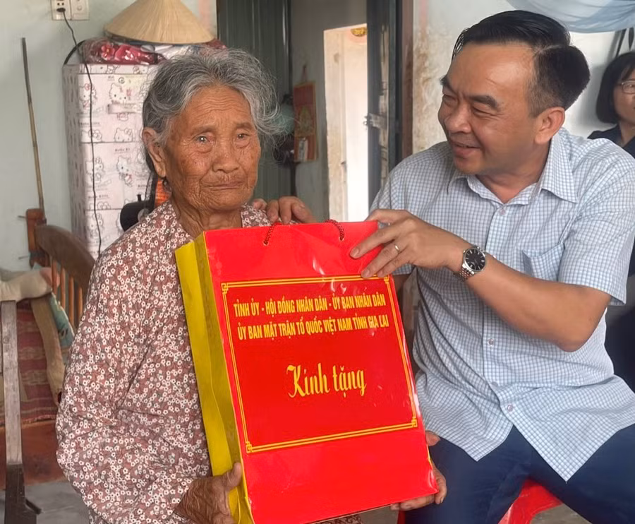 Phó Giám đốc Sở Lao động-Thương binh và Xã hội tỉnh Đặng Phan Chung tặng quà bà Nguyễn Thị Sự (dân công hỏa tuyến, xã Ia Hiao, huyện Phú Thiện). Ảnh: Vũ Chi