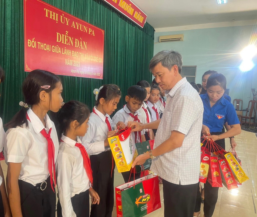Bí thư Thị ủy Ayun Pa Trần Quốc Khánh tặng quà cho các em học sinh vượt khó vươn lên trong học tập. Ảnh: Vũ Chi