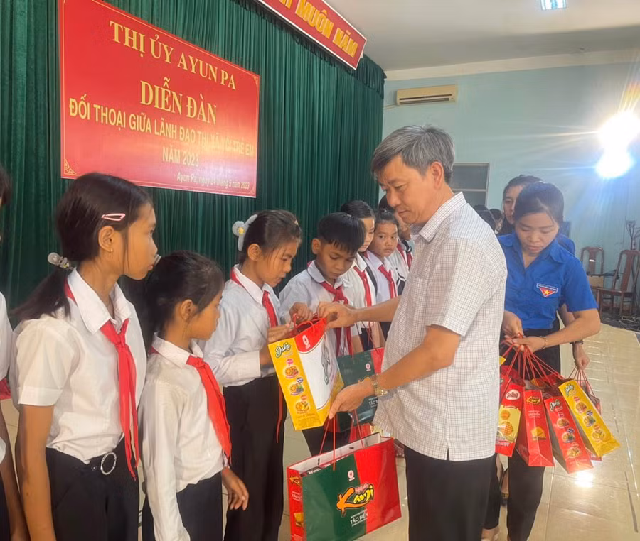 Bí thư Thị ủy Ayun Pa Trần Quốc Khánh tặng quà cho các em học sinh vượt khó vươn lên trong học tập. Ảnh: Vũ Chi