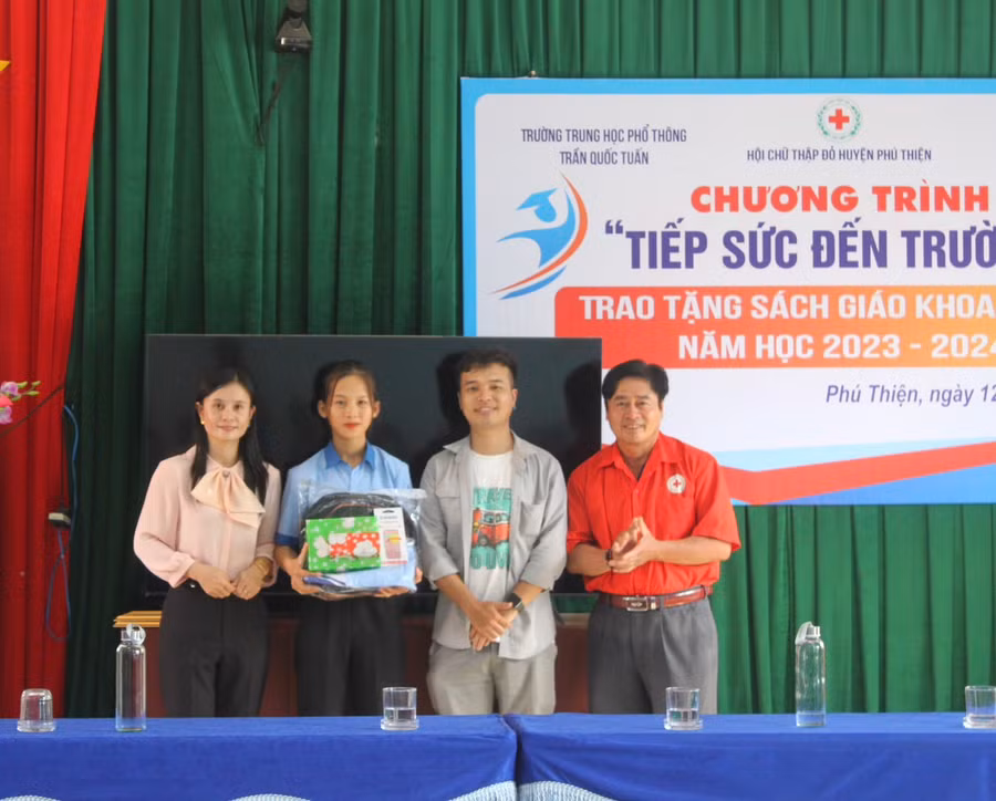 Đại diện hội từ thiện, Hội Chữ thập đỏ huyện Phú Thiện và cô Hoàng Thị Diệu Loan tặng quà cho em Vũ Thị Hằng (học sinh Trường THPT Trần Quốc Tuấn, mồ côi cả cha lẫn mẹ). Ảnh: Vũ Chi