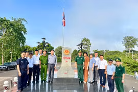 Đoàn công tác chụp ảnh lưu niệm tại cột mốc số 30-Cột mốc biên giới giữa tỉnh Gia Lai và Campuchia. Ảnh: Hà Duy