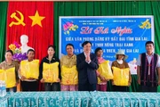 Đại diện lãnh đạo Văn phòng đăng ký đất đai tỉnh tặng quà cho các hộ nghèo tại buôn Ji. Ảnh: Thanh Tâm