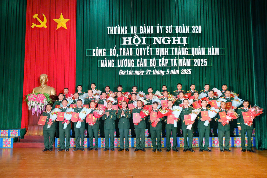 Lãnh đạo Sư đoàn 320 trao quyết định và tặng hoa chúc mừng các sĩ quan được nâng lương, thăng quân hàm. Ảnh: Vĩnh Hoàng cac-si.jpg