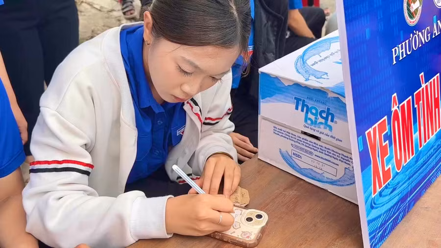 doan-vien-thanh-nien-ho-tro-thi-sinh-ghi-thong-tin-ca-nhan-len-dien-thoai-truoc-khi-gui-vao-khu-vuc-bao-quan.jpg