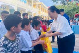 Bà Ksor H'Khuyên (Phó Chủ tịch UBND thị xã) trao quà cho các em học sinh có hoàn cảnh khó khăn. Ảnh: Vũ Chi
