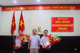 Phó Bí thư Tỉnh ủy Rah Lan Chung (đứng giữa) trao quyết định và tặng hoa chúc mừng đồng chí Nguyễn Hoàng Phong (bìa trái) và Vũ Hồng Duy. Ảnh: Vũ Chi