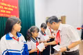 Chủ tịch UBND phường Ayun Pa Đặng Quang Khanh tặng quà cho các em học sinh tham gia hội nghị. Ảnh: Vũ Chi