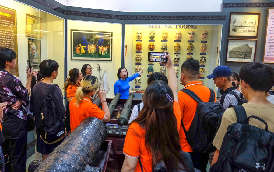 Thuyết minh viên Bảo tàng tỉnh Gia Lai giới thiệu đến học sinh về bộ sưu tập mặt nạ hát bội. Ảnh: Ngọc Nhuận dscf1481.jpg