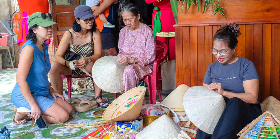 Mẹ con nghệ nhân Huỳnh Thị Thể trình diễn nghề làm nón lá. Ảnh: Ngọc Nhuận dscf2559.jpg