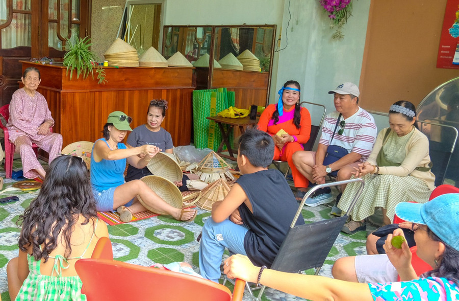 Du khách hào hứng trải nghiệm chằm nón. Ảnh: Ngọc Nhuận dscf2569.jpg