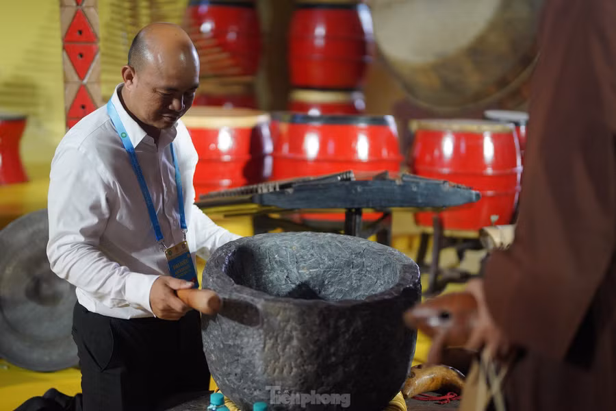 Du khách thích thú trải nghiệm gõ thử chiếc chuông bằng đá.
