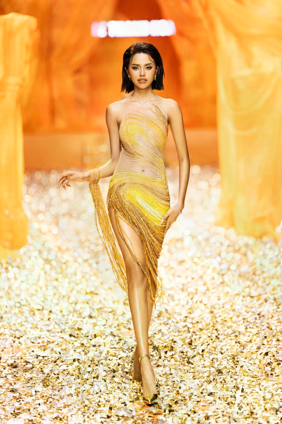 Màu vàng gold – biểu tượng của sự thịnh vượng, vinh quang và trường tồn là yếu tố chủ đạo xuyên suốt các thiết kế. Các chi tiết hoa văn, đường nét đặc trưng của phong cách Hòa Lai trong nghệ thuật điêu khắc Champa được khéo léo tái hiện qua nhiều kỹ thuật khác nhau, từ in ấn đến dập nổi, thêu đính...