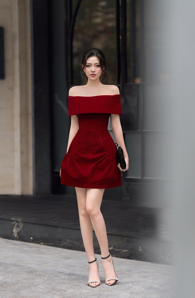 Chiếc đầm đỏ trễ vai là sự kết hợp hoàn hảo giữa vẻ gợi cảm và thanh lịch đầy quyền lực. Gam màu đỏ trầm sang trọng không chỉ tôn lên làn da sáng mịn mà còn thể hiện thần thái mạnh mẽ, cuốn hút, giúp người mặc trở nên nổi bật