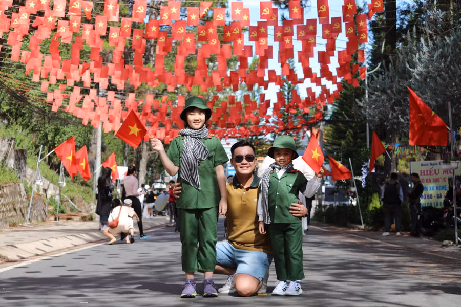 Các em bé với chiếc mũ và áo quân nhân nhỏ xinh, tay cầm cờ đỏ sao vàng, tạo nên hình ảnh vô cùng dễ thương.