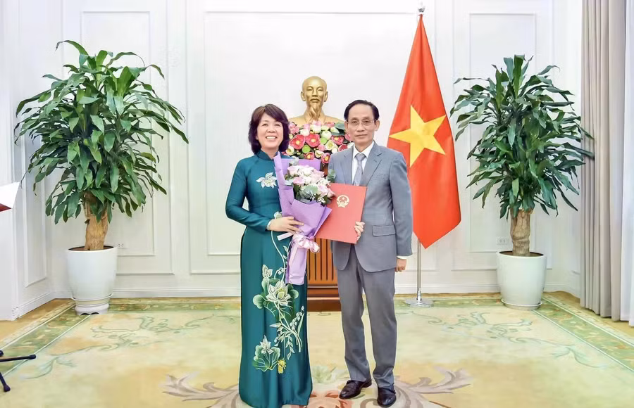 Bộ trưởng Bộ Ngoại giao Lê Hoài Trung trao quyết định của Thủ tướng Chính phủ và tặng hoa chúc mừng bà Nguyễn Thị Hoàng Vân được điều động, bổ nhiệm giữ chức Thứ trưởng Bộ Ngoại giao