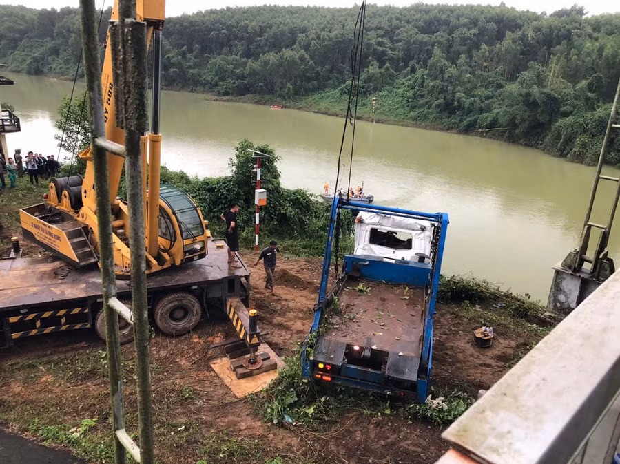 Chiếc xe xuồng chở rác sau khi rơi từ cầu treo xuống sông đã được trục vớt lên bờ.