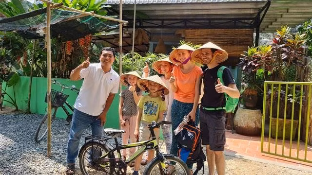 Anh Thịnh (bìa trái) dẫn đoàn khách quốc tế tham quan cảnh sắc miệt vườn