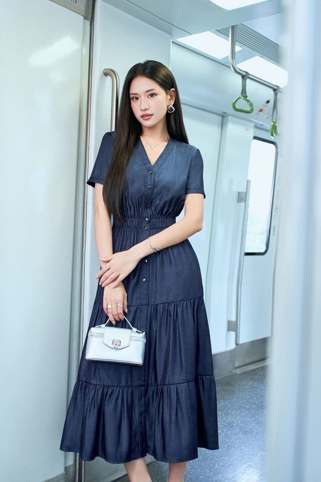 Thiết kế váy denim xếp tầng bồng bềnh duyên dáng với phần eo bo nhẹ tôn vòng eo thon gọn, cổ chữ V cùng hàng nút trước tạo điểm nhấn thanh lịch và hiện đại. Chất liệu denim mềm giúp váy giữ phom tốt nhưng vẫn thoải mái, dễ chịu trong mùa nắng