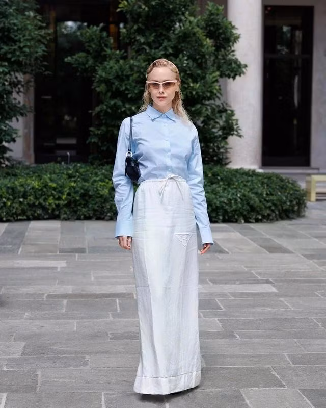 Lãng mạn hơn khi chiếc áo được "tỏa sáng" nhờ sự kết hợp với chân váy midi trắng nhẹ nhàng, đặc trưng bởi đường thêu kín đáo, trở thành bộ đồng phục không thể thiếu của mùa hè