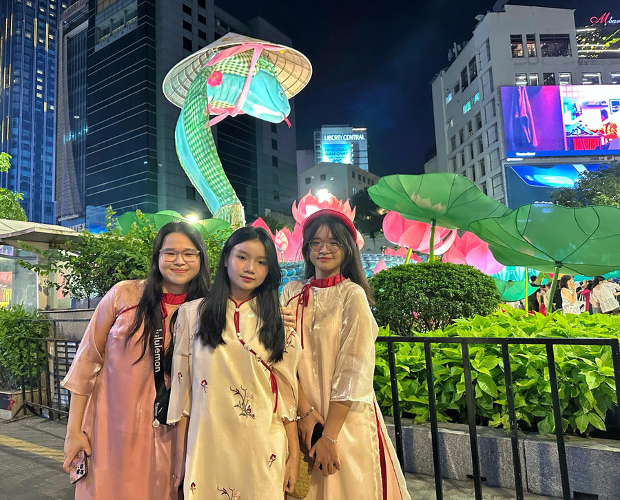 Gia đình của chị Quỳnh Như (27 tuổi) tối nay đi từ TP.Thủ Đức đến đường hoa Nguyễn Huệ để đón giao thừa. Chị Như (trái cùng) cho biết rất thích không khí đông đúc ở đây và vô cùng ấn tượng với linh vật rắn khổng lồ ở đường hoa. &quot;Chúc mọi người đón một năm mới vạn sự như ý, hạnh phúc bên gia đình và người thân&quot;, kế bên chị Như Ý (20 tuổi) là em chị Như nói thêm