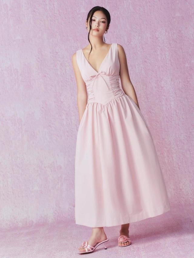 Gam màu hồng pastel trên thiết kế cotton gây ấn tượng với phần cổ chữ V, phần eo hông xếp nhún tạo hiệu ứng thị giác mang lại hình ảnh ngọt ngào và lãng mạn cho nàng