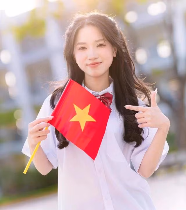 Các bạn học sinh chụp ảnh kỷ yếu với cờ Tổ quốc để lan tỏa tinh thần yêu nước