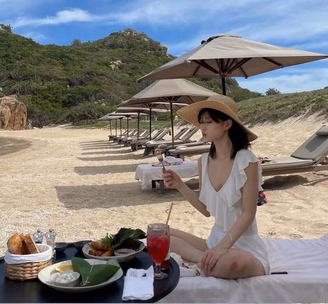Người đẹp 26 tuổi thích thú thưởng thức đồ ăn ngon bên bãi biển