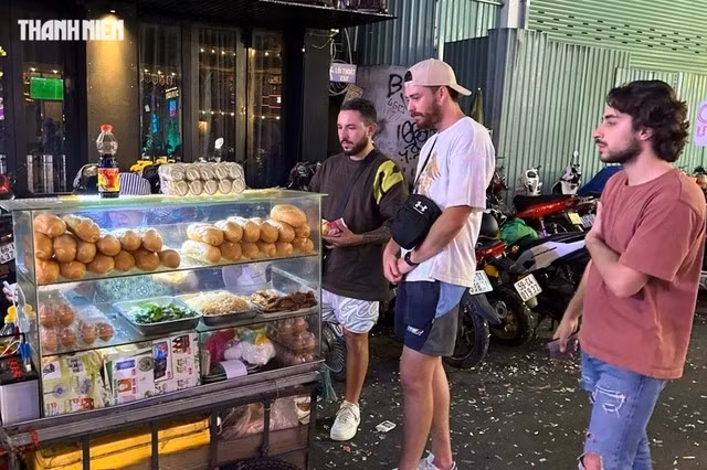 Du khách nước ngoài thưởng thức bánh mì, món ăn đường phố được ưa chuộng, ở khu phố Tây Bùi Viện, Q.1