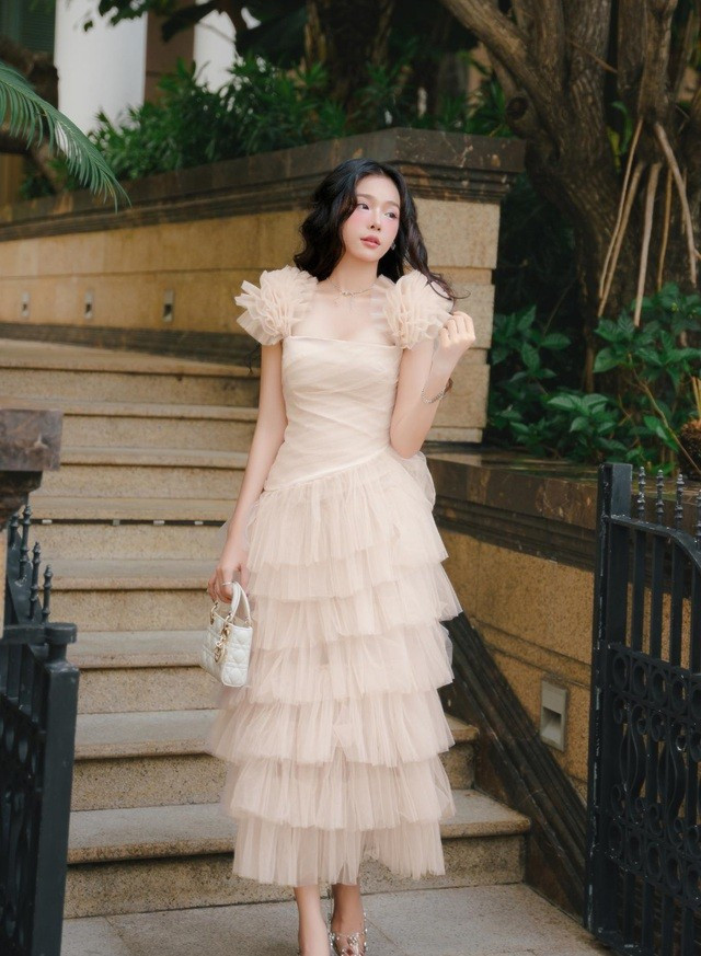 Từng lớp vải lưới mỏng manh, xếp tầng buông rơi như những dải thạch nhũ lấp lánh. Nhà mốt thổi hồn vào thiết kế bằng kỹ thuật dựng phom cao cấp, khai mở kết cấu bất đối xứng đầy tính nghệ thuật