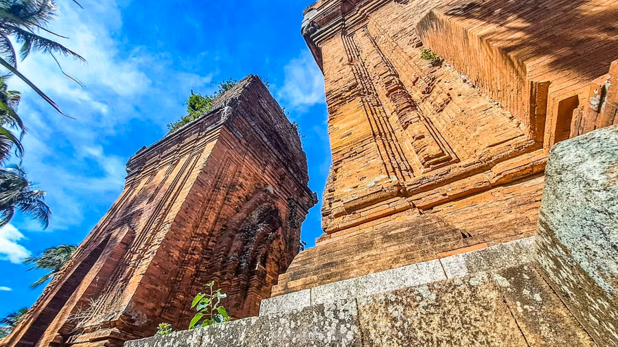 Ở Tháp Đôi, bên cạnh những yếu tố kiến trúc của một ngôi tháp Chăm truyền thống, như khối thân vuông, cửa chính quay về hướng Đông, 3 mặt còn lại là 3 cửa giả, thì ở Tháp Đôi còn hiện lên những nét đặc trưng với khối hình lớn, vòm cửa ra vào và cửa giả vút lên như hình mũi giáo… Ảnh: Trương Định.