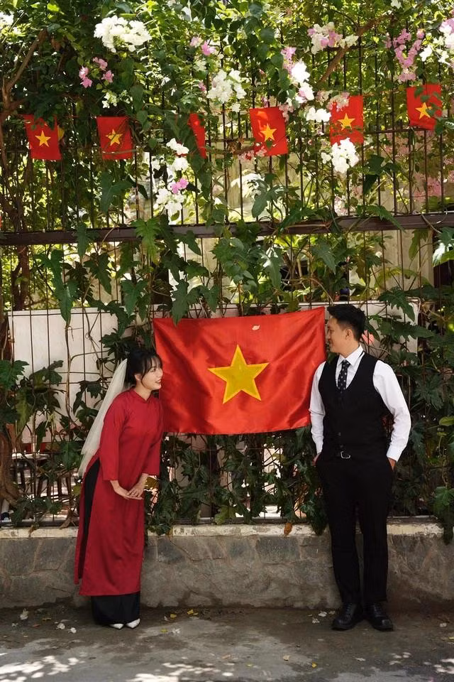 Cặp đôi chụp hình cùng lá cờ đỏ sao vàng
