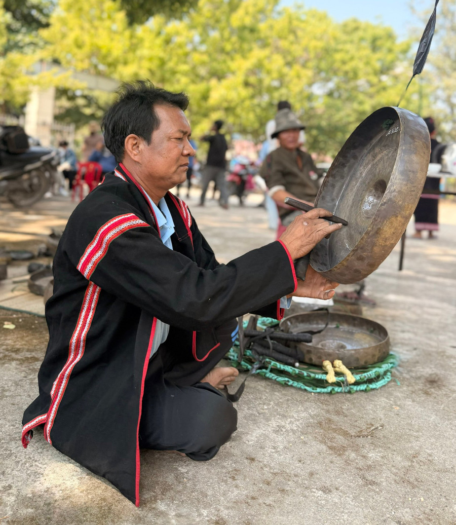 Nghệ nhân Ksor Kốk chỉnh lại chiếc chiêng bị lệch âm. Ảnh: V.T.T ben-goc-lang-nghe-nhan-ksor-kok-tap-trung-chinh-lai-chiec-chieng-bi-lech-am-chuan-bi-cho-le-cung-cau-mua-tai-thon-mlah.jpg
